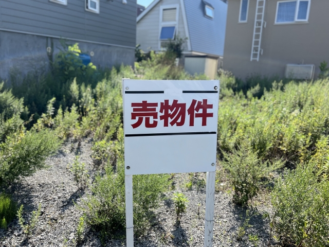 草の伸びた敷地に立つ売物件の看板。相続した空き家は売る・貸す・管理するの3つから選ぶことになる