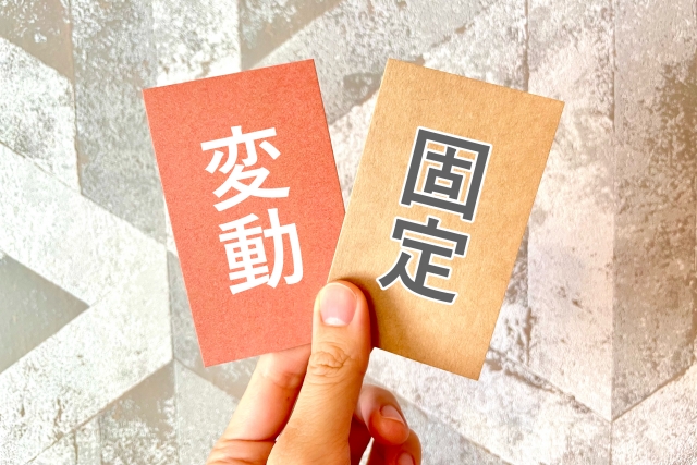 「変動」と「固定」と書かれた2枚のカードを手に持つ様子