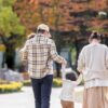公園の並木道を歩く家族の後ろ姿。遺族年金は2028年4月に改正され、受け取れる期間が世帯によって変わる